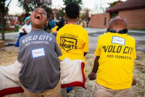 Children laughing and wearing Volo Sports t-shirts as part of the SBGP Sports Network.